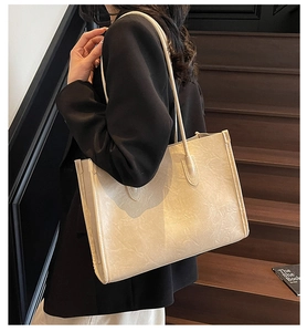 Detail of beige soft PU tote bag featuring a pleated leather texture and large capacity
