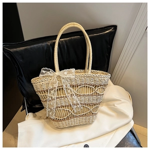 Detailed macro view of summer woven tote bag featuring a white lace bow decoration