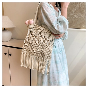 Detailed close-up of woven tote bag featuring fringe tassels and diamond mesh pattern