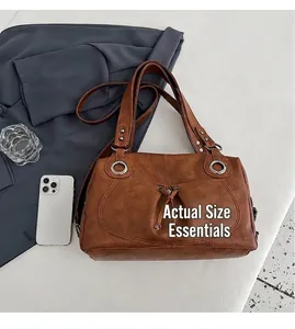 Detail of brown vintage tote bag showing silver metal eyelets and decorative drawstring