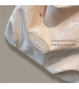 Detailed close-up of marble pattern texture and embossed brand logo on the tote bag