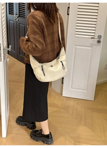 Détail du sac hobo rétro en similicuir crème avec poches zippées et bandoulière