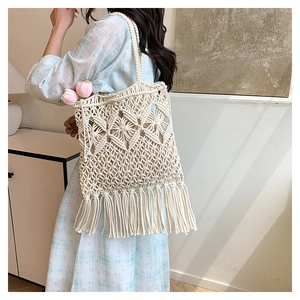 Detailed close-up of bohemian woven tote bag featuring geometric patterns and hanging tassels