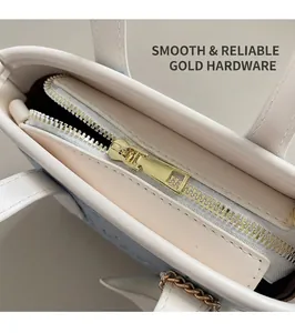 Détail d'une fermeture éclair en métal doré sur un sac seau en cuir blanc de qualité