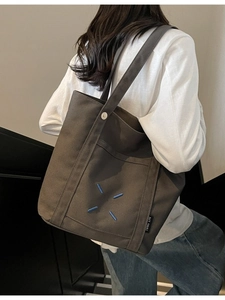Minimalist large canvas tote bag in dark brown with blue cross-stitch design for women
