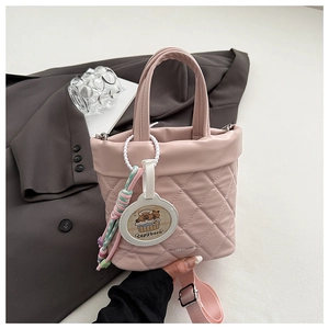 Detailed view of pink quilted bucket bag with cute Capybara charm and wide strap