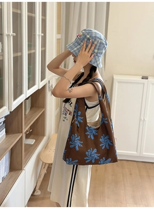 Detailed view of the nylon printed crescent bag with blue abstract patterns on brown fabric