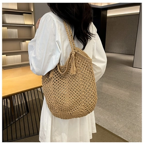 Vue détaillée du sac cabas en paille tissée avec pompon décoratif et motif ajouré chic