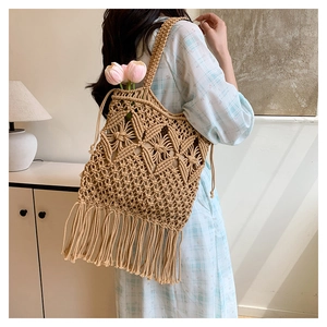 Detail of hand-woven beige tote bag with fringe accents and geometric knit pattern