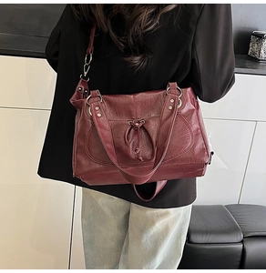 Detail view of burgundy tote bag with drawstring texture and long shoulder strap