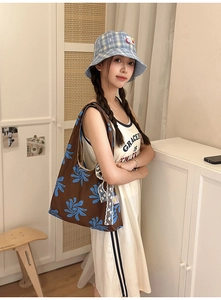 Brown nylon crescent bag with blue floral print and lace trim detail on model