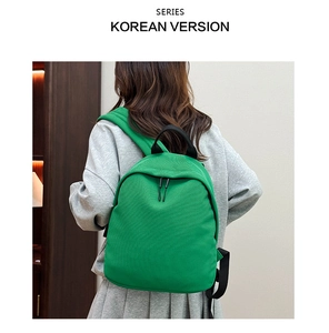 Close-up of bright green Oxford backpack with black zipper detail and sturdy top handle