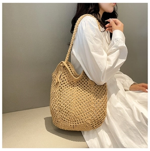 Detail of hand-woven mesh shoulder bag with tassels for summer beach vacation style