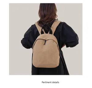 Detail view of the khaki Oxford fabric backpack with fine woven texture and black handle