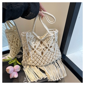 Close-up of bohemian cream macramé tote bag featuring intricate woven patterns and long fringe