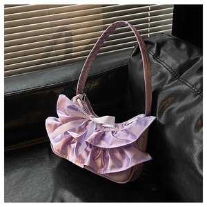 Detail of lavender satin handbag with layered ruffles and white ribbon bow accent