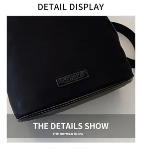 Detailed macro view of black shell backpack showing fine nylon texture and logo plaque