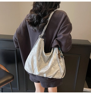 Detail of silver-grey hobo bag with marble texture and branded logo plate