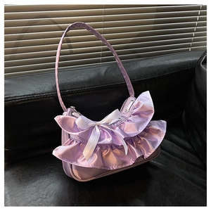 Detailed view of lavender satin fabric with tiered ruffles and white ribbon bow accent