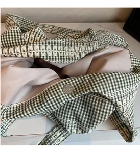Detail view of green and white plaid tote bag showing interior lining and magnetic closure