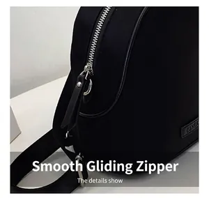Detail of smooth silver zipper with leather pull on a black waterproof nylon backpack