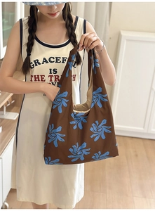 Close-up of lightweight nylon crescent bag with blue abstract floral prints on brown fabric
