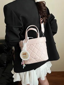 Pink quilted bucket bag with crossbody strap and cute cartoon capybara pendant charm
