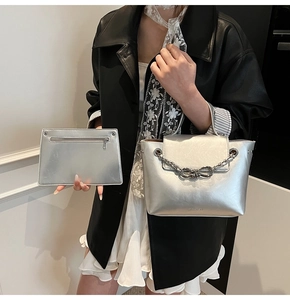 Detail of silver crossbody bag set with metal chain and matching zipper pouch in PU leather