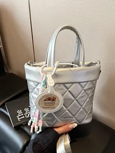 Silver quilted bucket bag with metallic finish and cute capybara pendant accessory