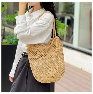 Détail d'un sac cabas en paille tissé à la main avec motif ajouré et longues franges
