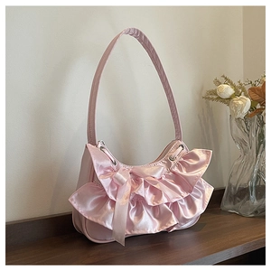 Detail of pink satin handbag featuring layered ruffle pleats and a matching silk bow
