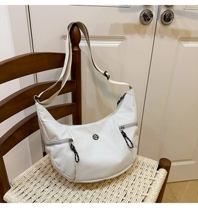 Détail du sac bandoulière blanc avec double zip et bandoulière en tissu tissé