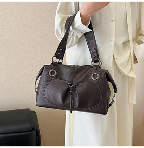 Detailed view of dark brown vintage leather tote with decorative drawstring and silver rings