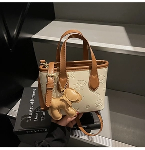 Détail du mini sac seau avec motif de chien gaufré et breloque en cuir assortie