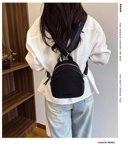 Detailed back view of a chic black mini shell backpack with silver zippers and nylon straps