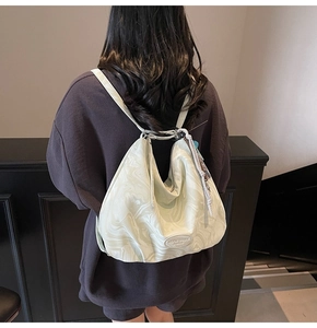 Detail of white marble pattern tote with circular logo and woven zip puller