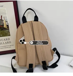 Detail view of the khaki oxford backpack back pocket showing mobile phone storage space