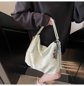 Chic mint green hobo bag with marble texture shown on a shoulder in a lifestyle setting