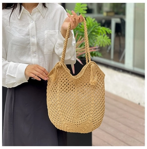 Détail du sac cabas tissé ajouré avec glands et anses tressées pour l'été plage