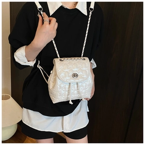 Detail view of pearl white small backpack with star quilting and chain straps