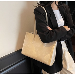 Detail of beige soft PU leather tote bag with crinkled texture and long shoulder straps
