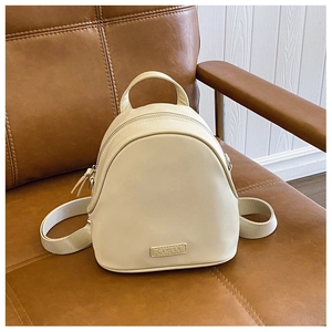 Detailed view of cream PU leather shell backpack with C&HEKA brand plaque on leather seat