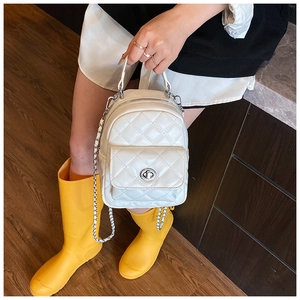 Quilted beige mini backpack detail showing silver twist lock and leather chain straps