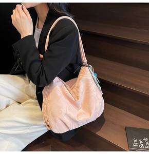 Detail of pink marble pattern tote bag with decorative bead tassel in a street style setting