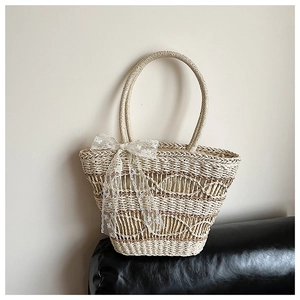 Detailed view of woven straw tote bag featuring white lace bow and natural fiber texture