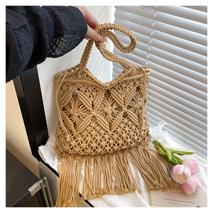 Close-up of handmade macrame tote bag with intricate woven patterns and long fringe tassels