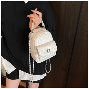 Close-up of a white quilted leather mini backpack with silver chain and metal turn-lock