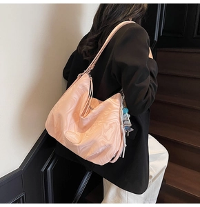 Detail of pink marble pattern tote bag with cartoon charm on elegant shoulder bag