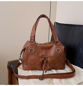 Detail of a brown vintage leather tote with metal buckle and adjustable shoulder strap