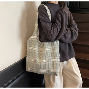 Detail of green and white checkered tote bag showing large capacity and thick knit texture